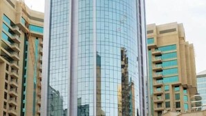 A modern, curved glass building labeled "VITA Tower" with a clear sky in the background.