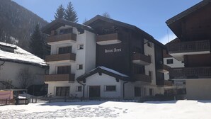 A multi-story building with balconies, a sign reading "Haus Ares," and a snowy ground. - Haus Ares (Zermatt)