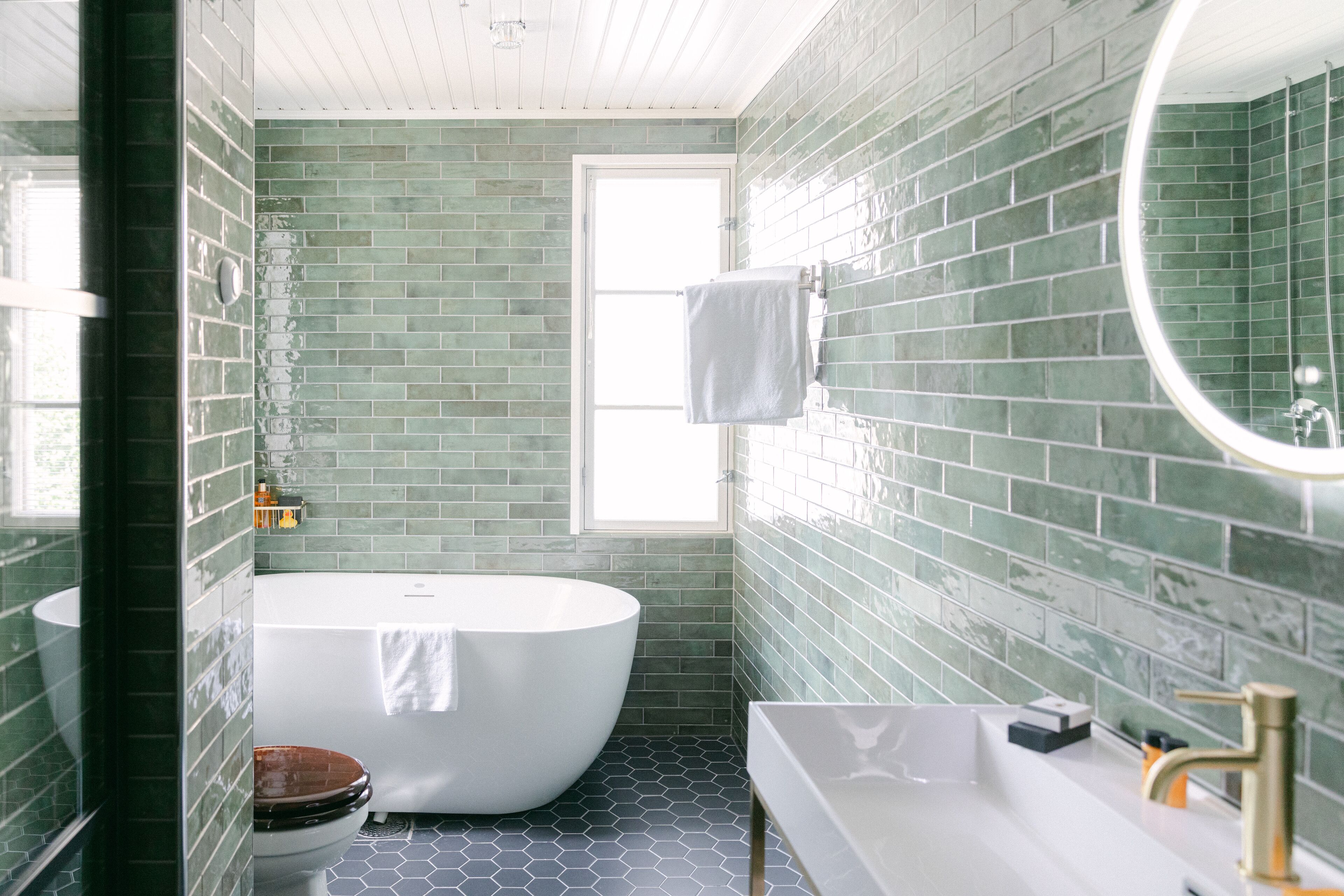 A bathroom with a freestanding bathtub, a white sink, and a toilet.