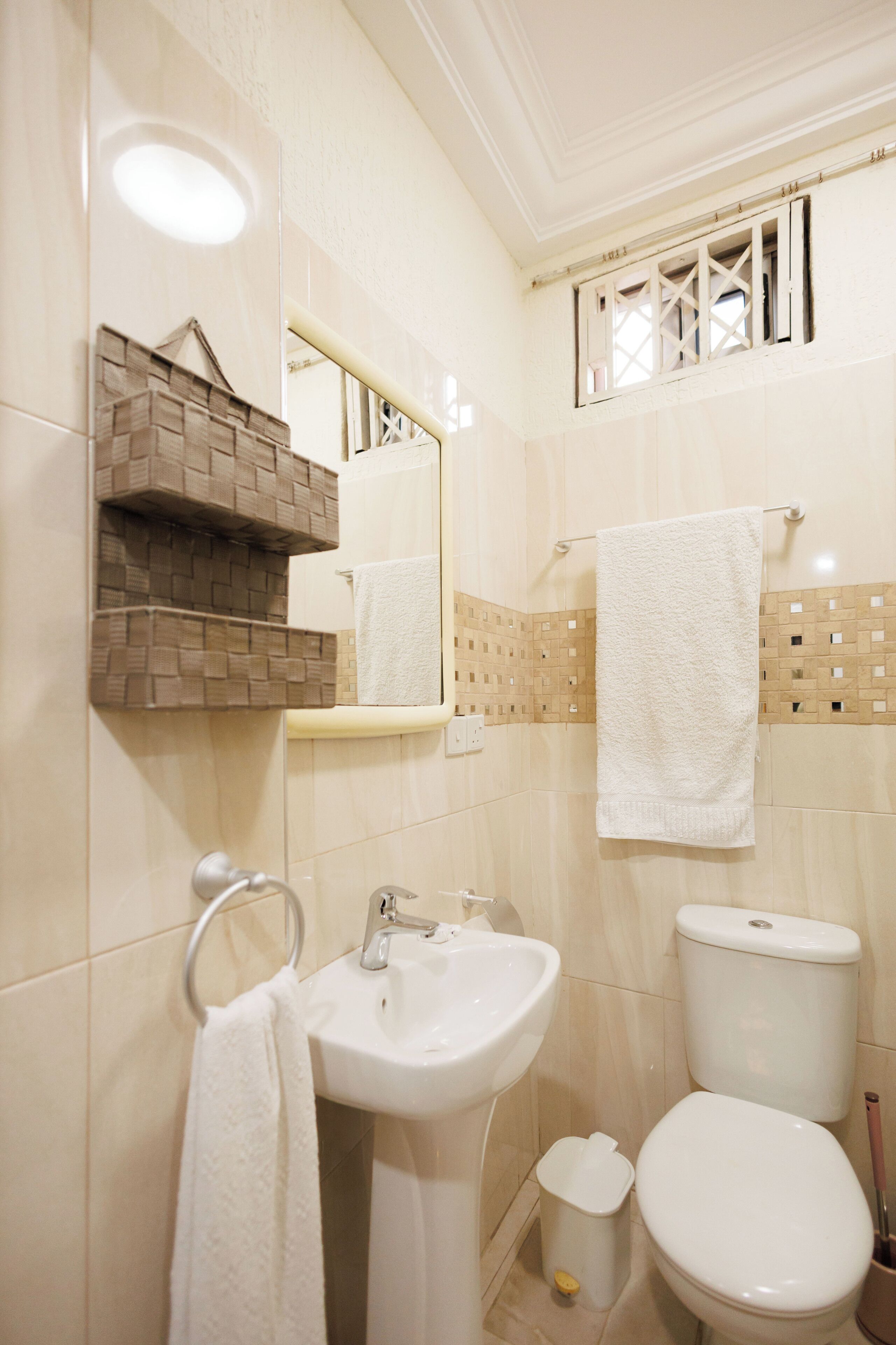 Un baño con lavamanos, inodoro y espejo.