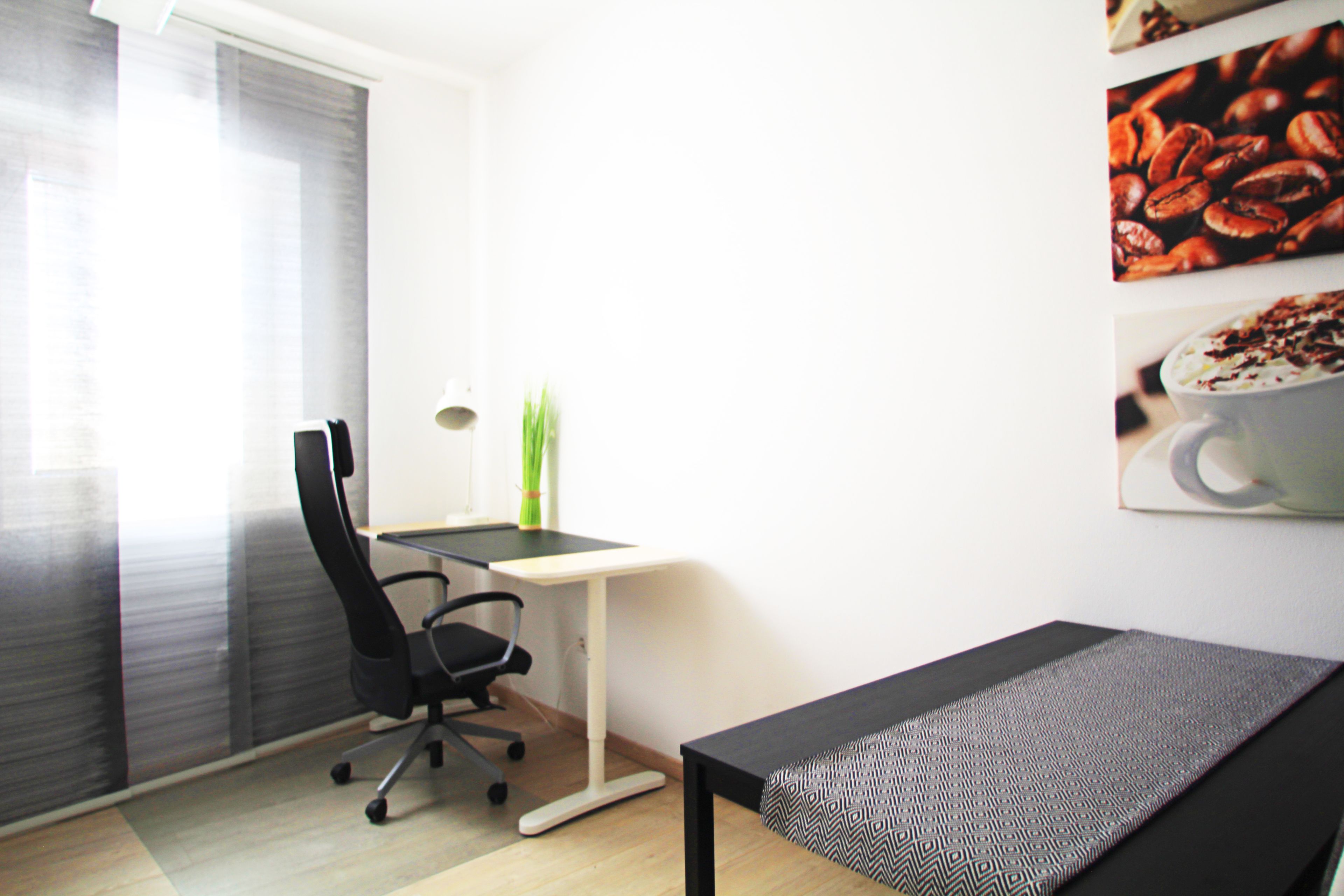 A modern office space with a desk, chair, and a bench.