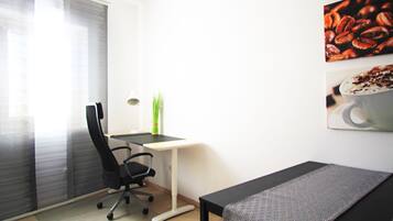 A modern office space with a desk, chair, and a bench.
