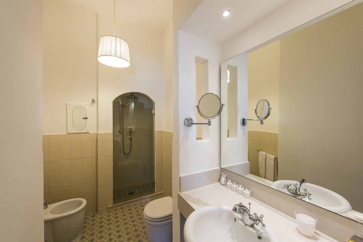 Une salle de bain moderne avec une douche à parois de verre, un double vasque et un grand miroir.