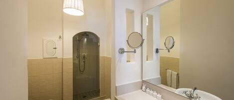 Une salle de bain moderne avec une douche à parois de verre, un double vasque et un grand miroir.