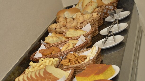 Un bufé con panes, pasteles y un pastel.
