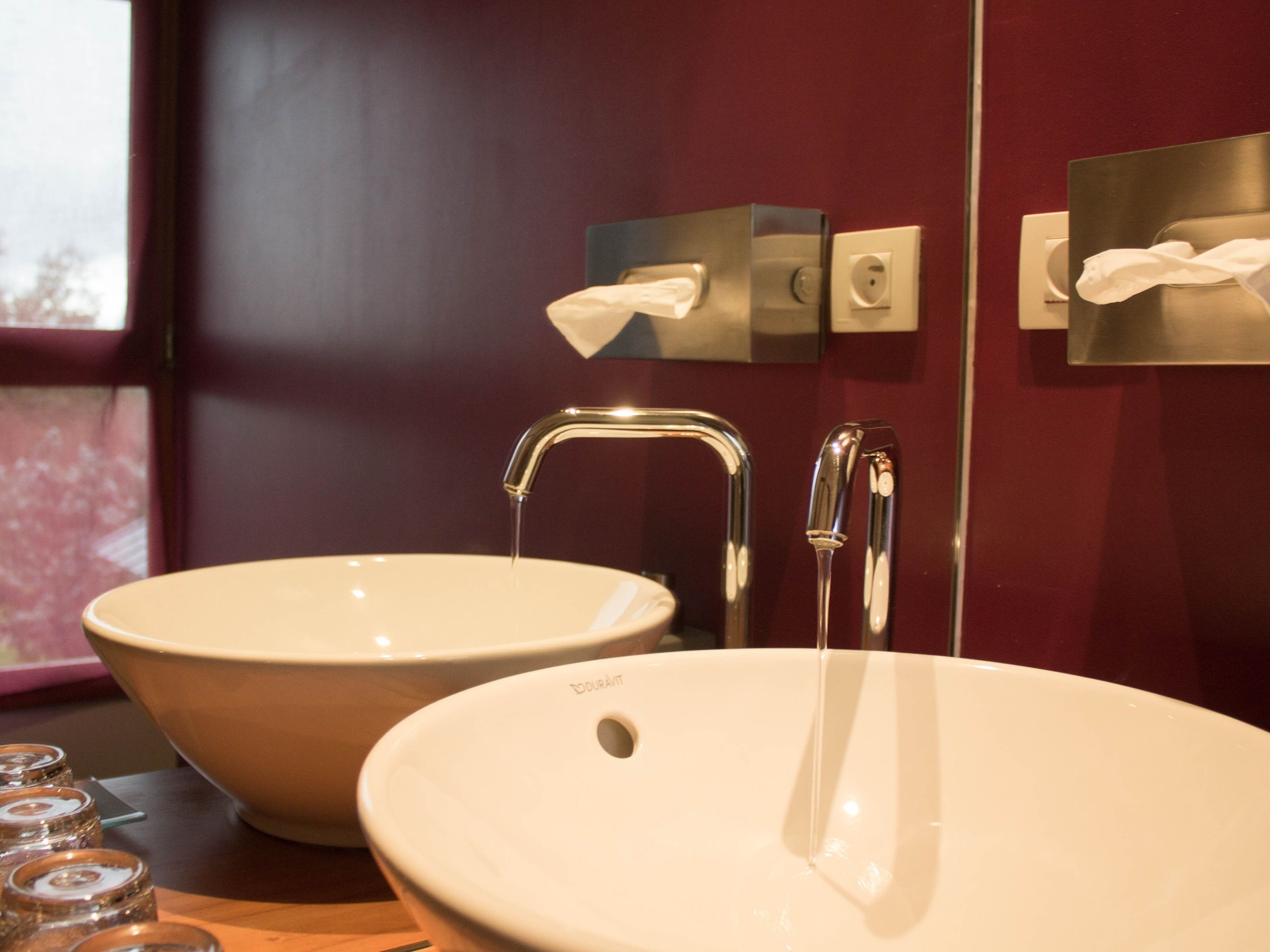 A bathroom with two sinks, a mirror, and a window.