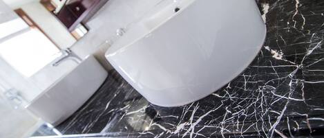 A bathroom with a white sink and a marble countertop.