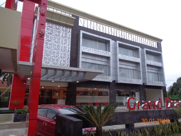 Un hotel con fachada moderna, amplias ventanas y una entrada destacada.