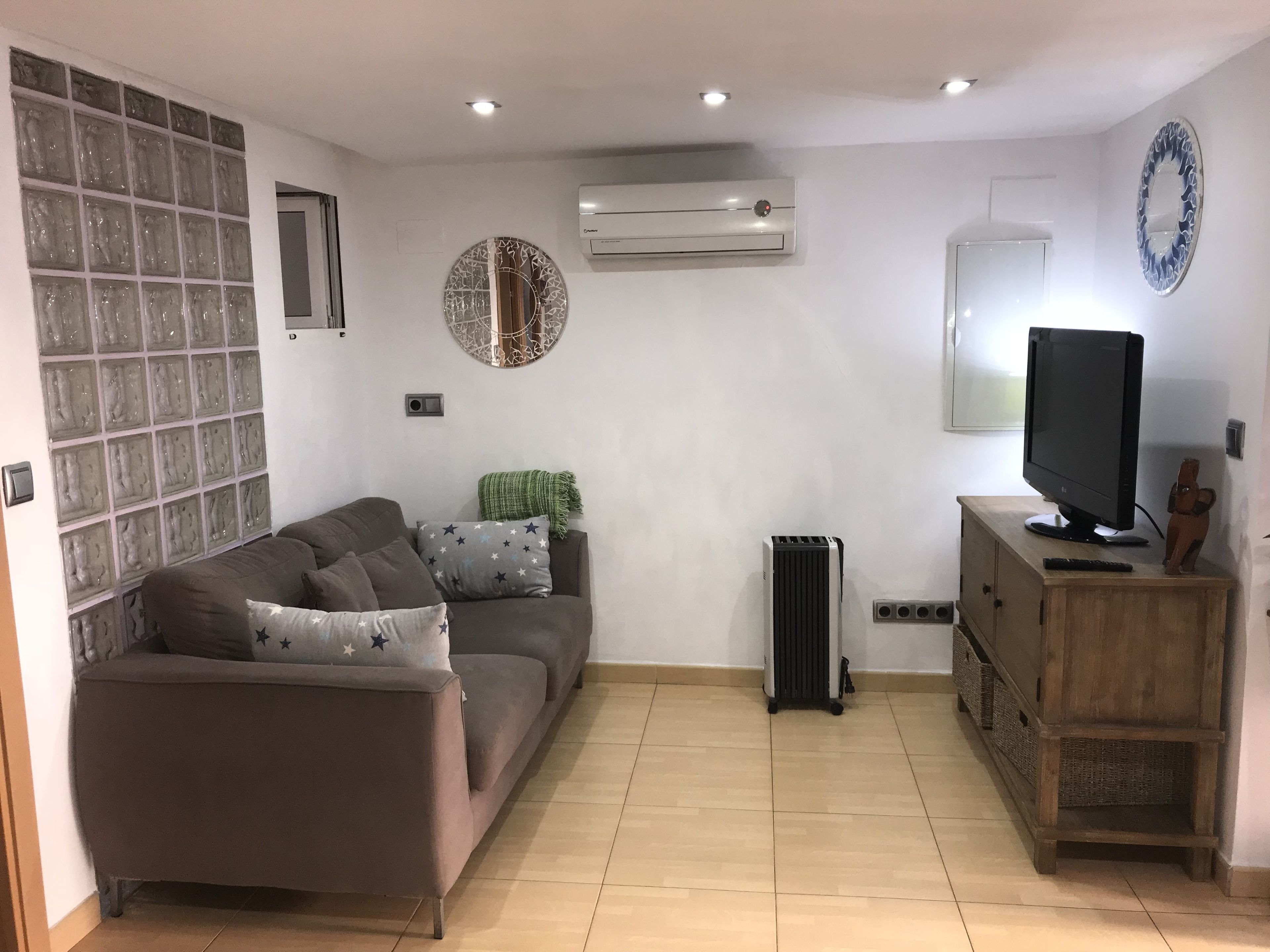 A living room with a sofa, a TV, and a radiator.
