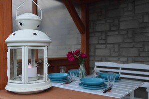 Ein weißer Laternenstern, ein Tisch mit blauen Tellern und eine Vase mit rosa Blumen.