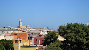 A coastal town with a prominent church tower, various buildings, and a clear blue sky.