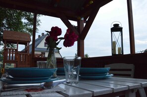 Ein Tisch ist gedeckt mit blauen Tellern, einem Glas und einer Blumenvase.