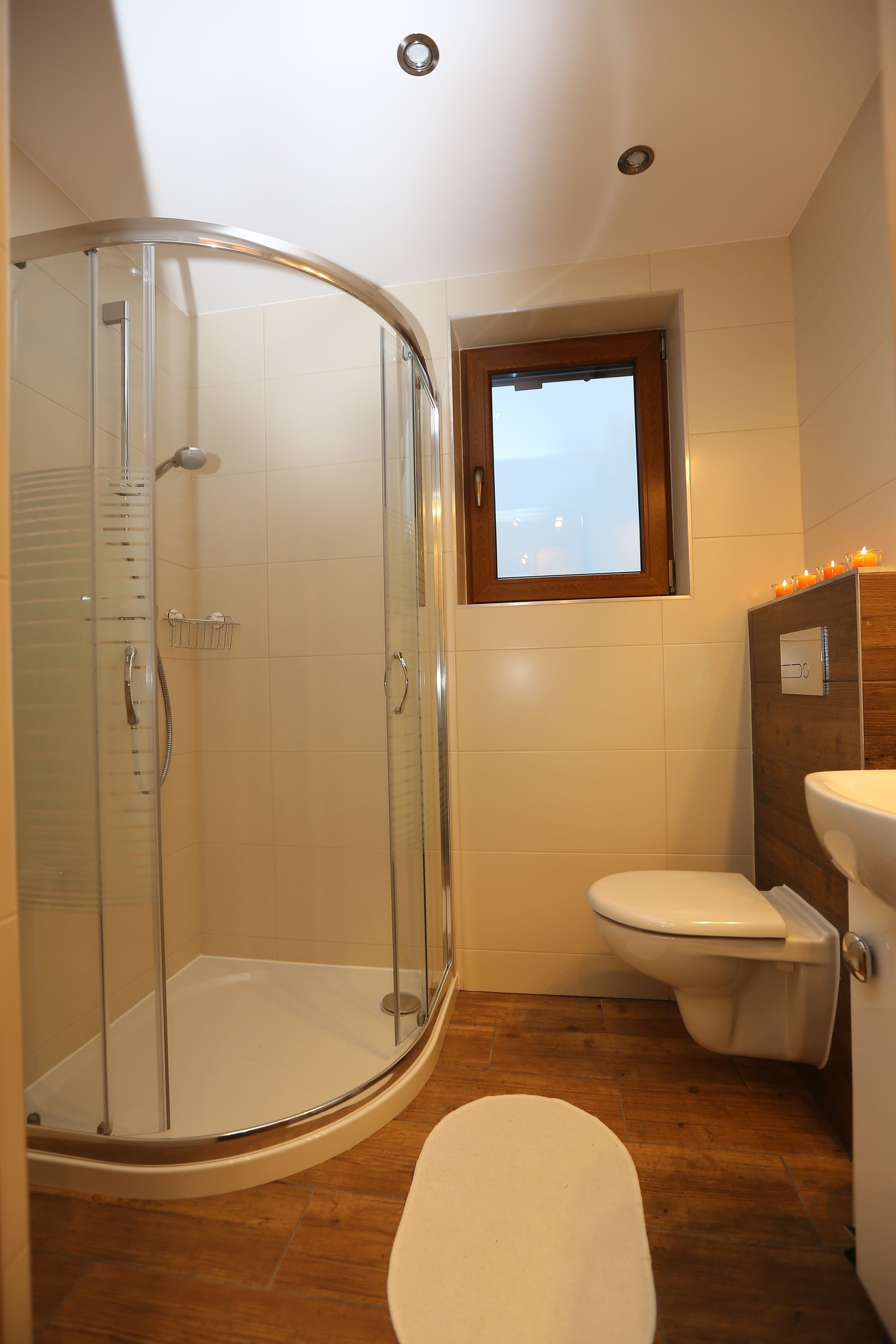 Une salle de bain avec une douche à parois de verre, des toilettes et un lavabo.