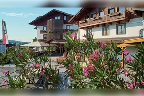 A hotel with multiple balconies, outdoor seating, and a clear sky. - Hotel Königgut (Wals-Siezenheim)