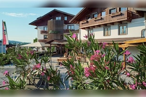 Un hotel con varios balcones, mobiliario exterior y cielo despejado.