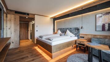 A modern bedroom with a wooden bed, bedside table, and a small desk with a chair.