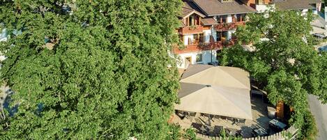 A residential area with a house featuring a balcony and a covered outdoor seating area.