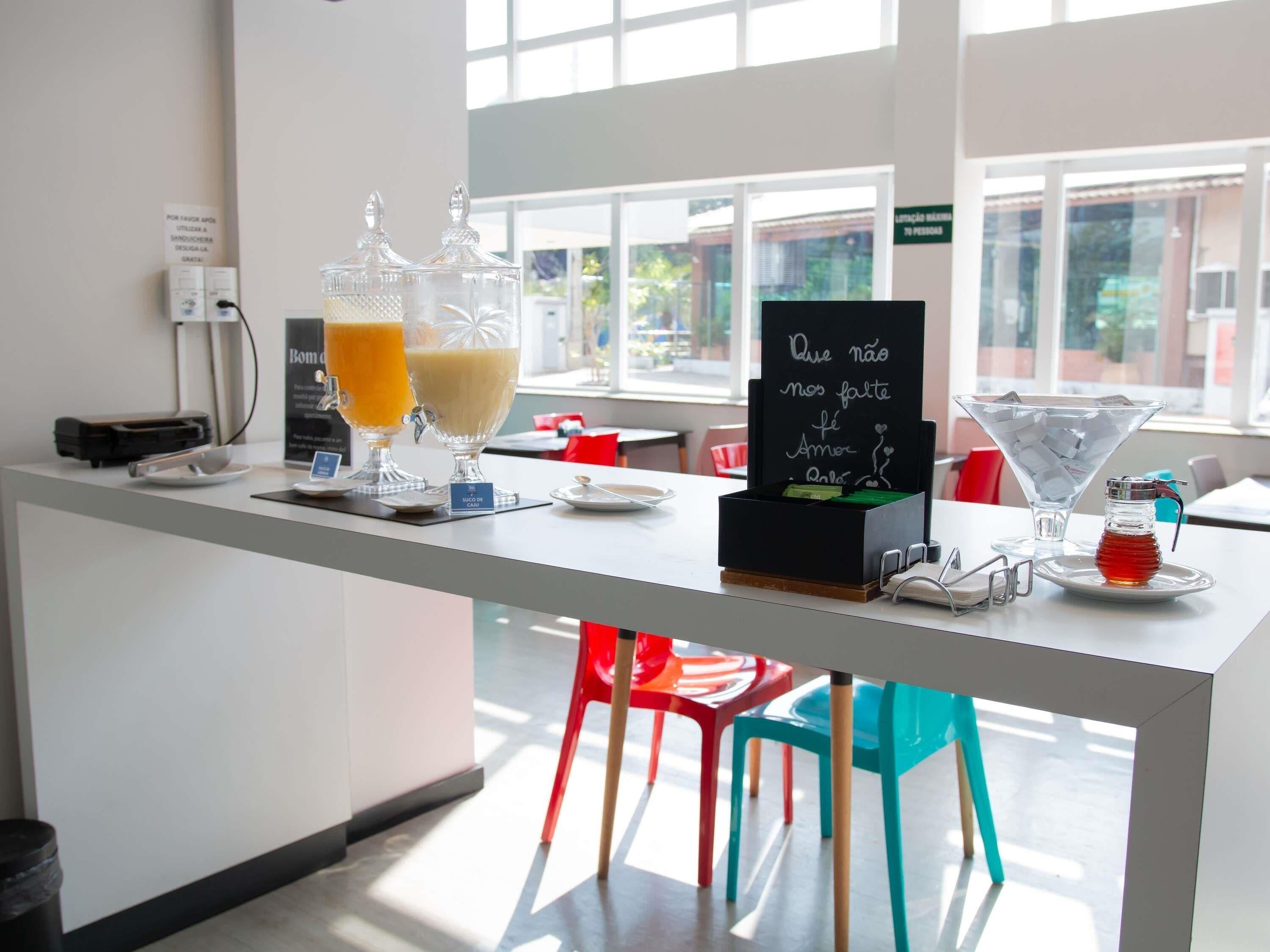 A bar area with a chalkboard sign, a martini glass, and a juice dispenser.