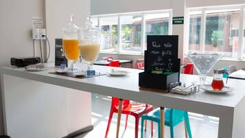 A bar area with a chalkboard sign, a martini glass, and a juice dispenser.