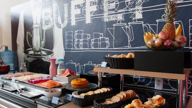 A buffet setup with various food items and a chalkboard sign. - ibis budget Muriae (Muriae)