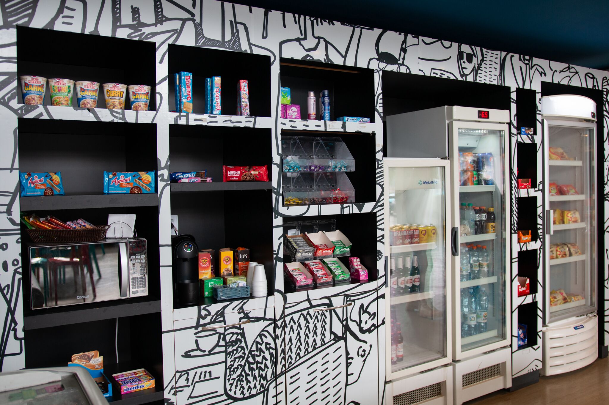 A vending machine with various snacks and drinks, a microwave, and a refrigerator with beverages.