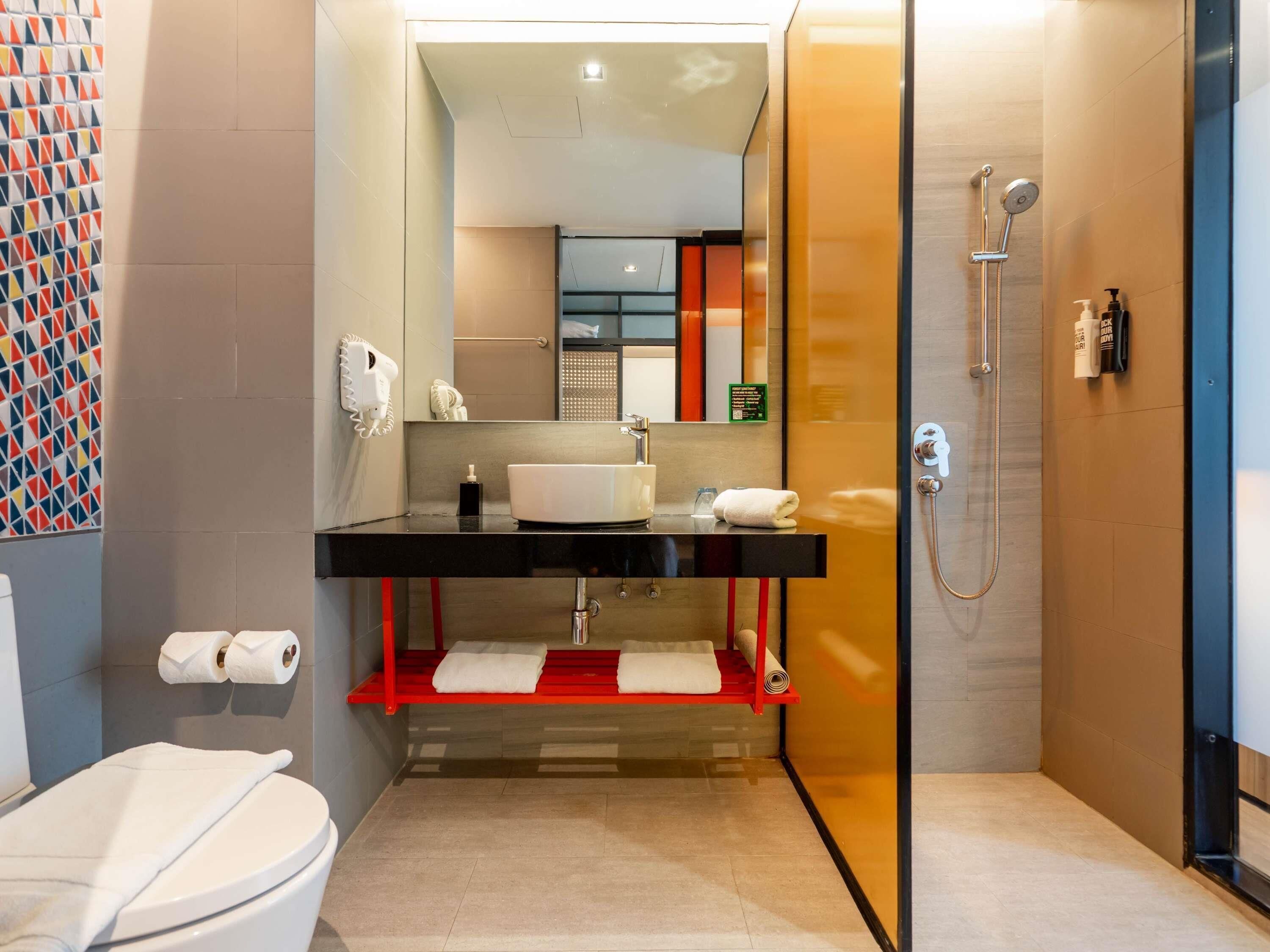 A modern bathroom with a toilet, sink, and shower.