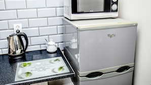 A kitchen with a white refrigerator, a microwave, a kettle, and a small white pitcher on the counter. - AP-Apartments Marszałkowska No. 53 (Warsaw)
