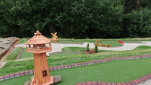 A model landscape with a wooden lighthouse, windmill, and a winding path. - Hotel Góralski Raj (Nowy Targ)