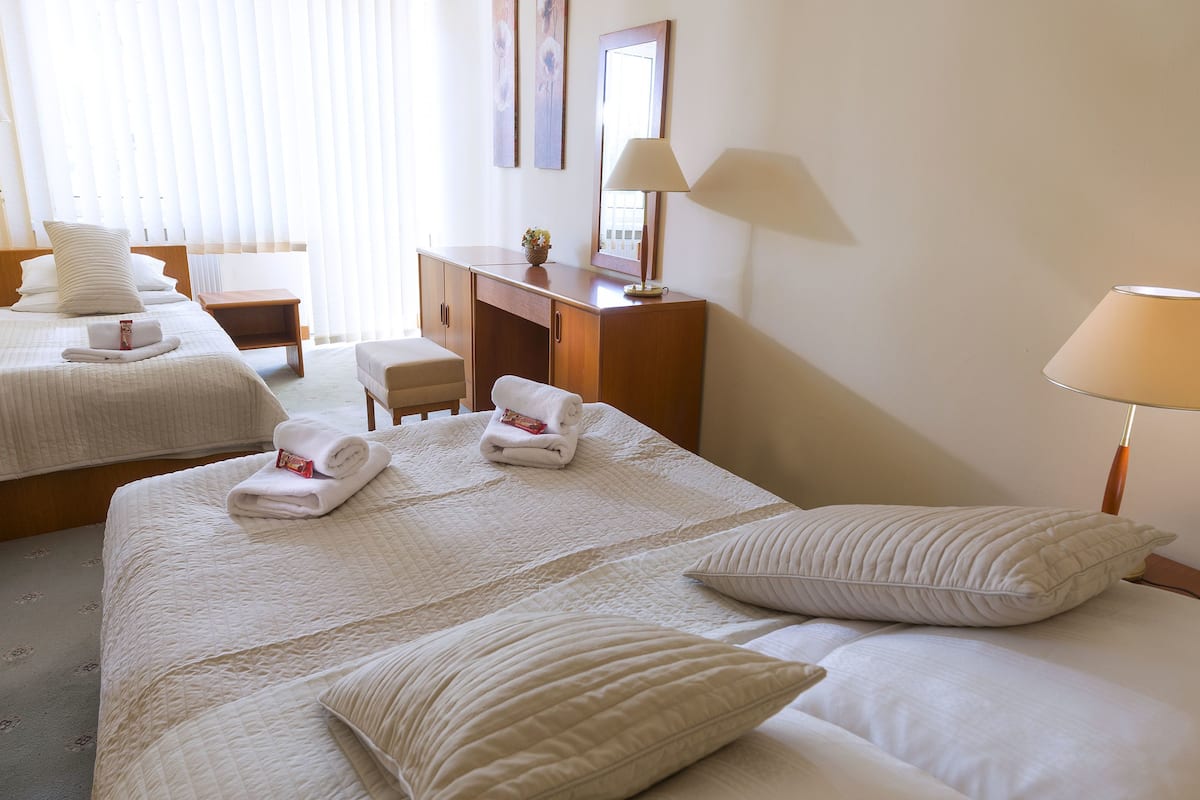 Escritorio, cortinas blackout y tabla de planchar con plancha