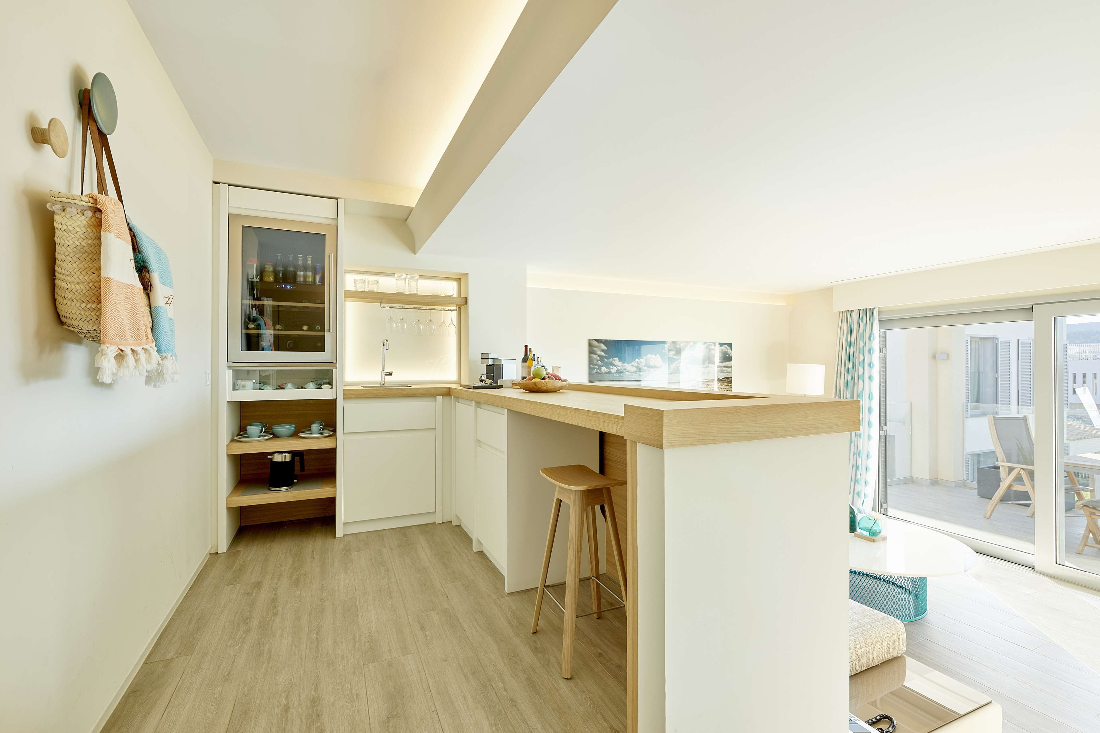 Une cuisine moderne dotée d’un plan de travail en bois, d’un four encastré et d’un garde-manger avec une porte en verre.