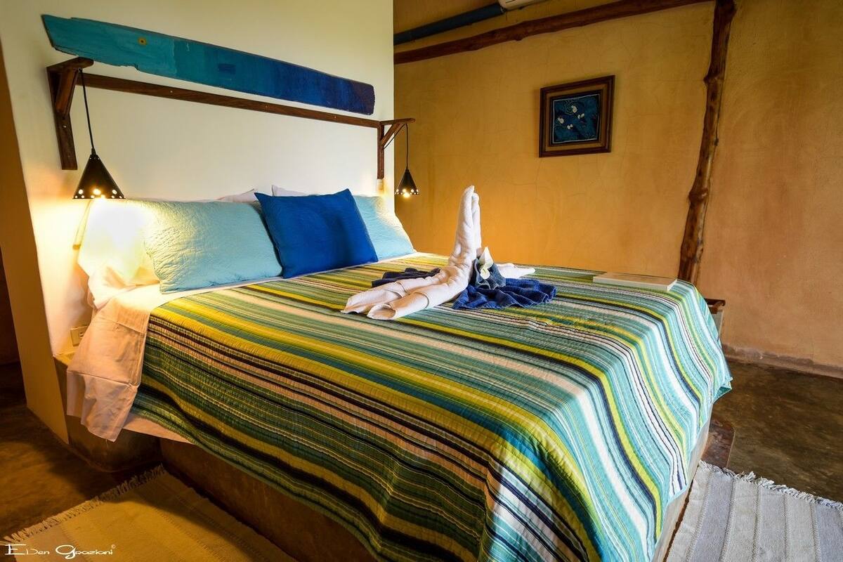 A bed with a striped bedspread, pillows, and a towel.