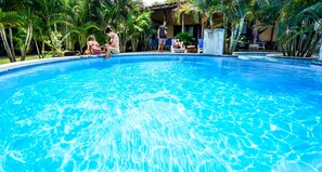 A swimming pool surrounded by palm trees and lounge chairs. - Casa Lajagua (Pedasí)
