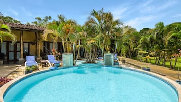 Una piscina al aire libre, tumbonas