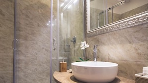 A modern bathroom with a glass-enclosed shower, a round sink, and a large mirror. - The golden keys rome (Rome)
