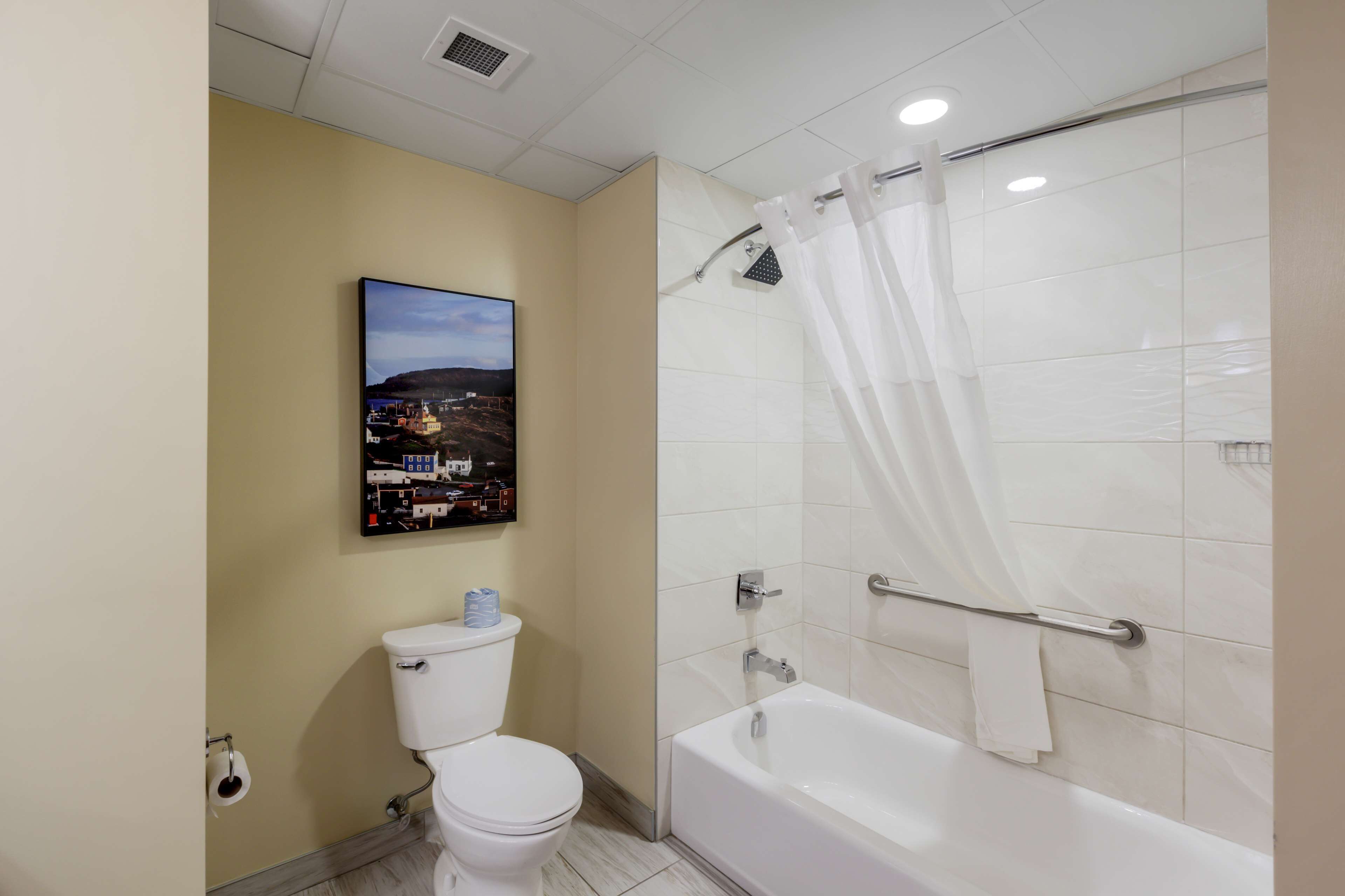 Un baño con inodoro, bañera y cortina de ducha.