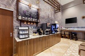 A modern coffee bar with a chalkboard menu, espresso machines, and a flat-screen TV. - Best Western Plus St. John's Airport Hotel and Suites (St. John's)