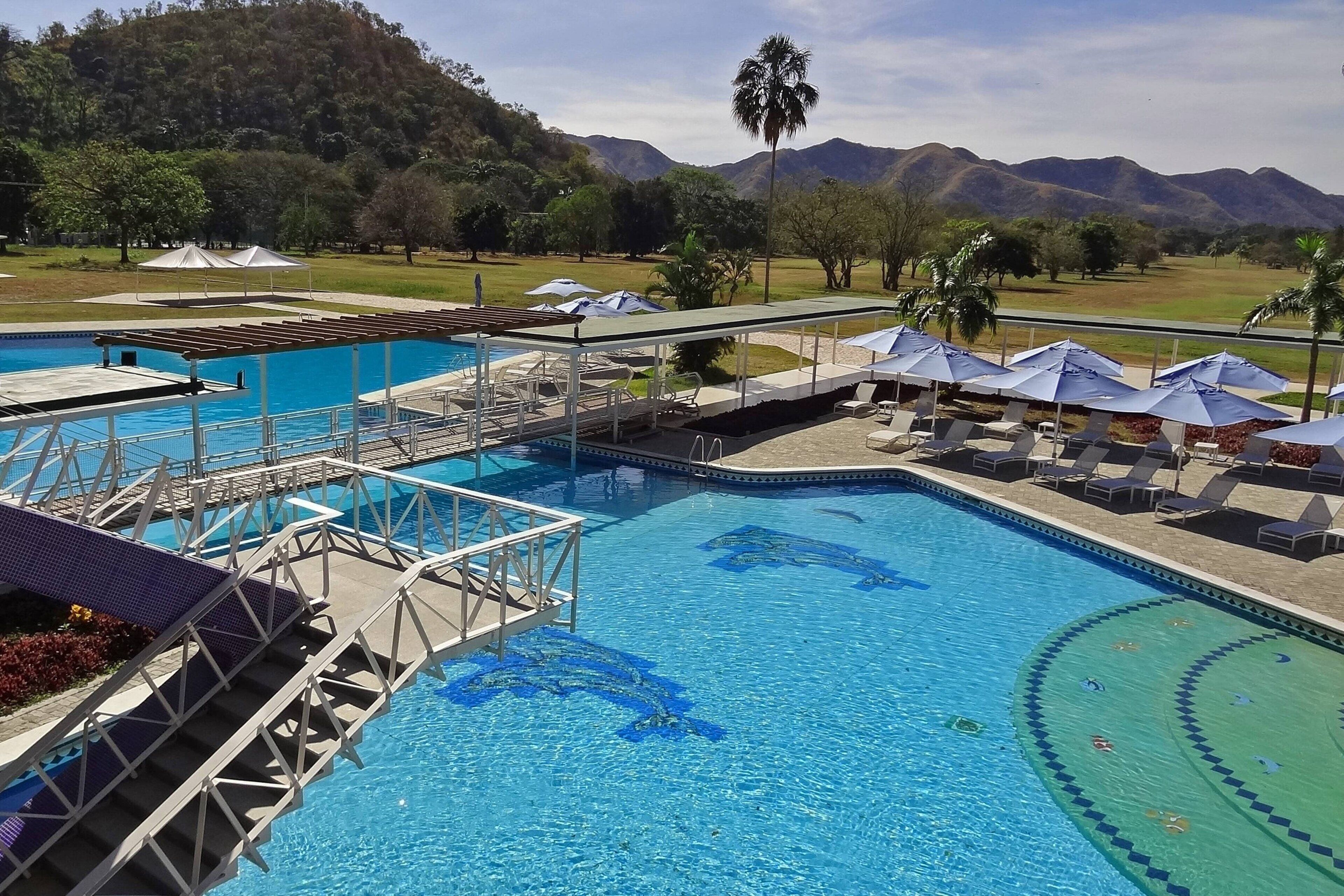 Outdoor pool, pool umbrellas, lifeguards on site