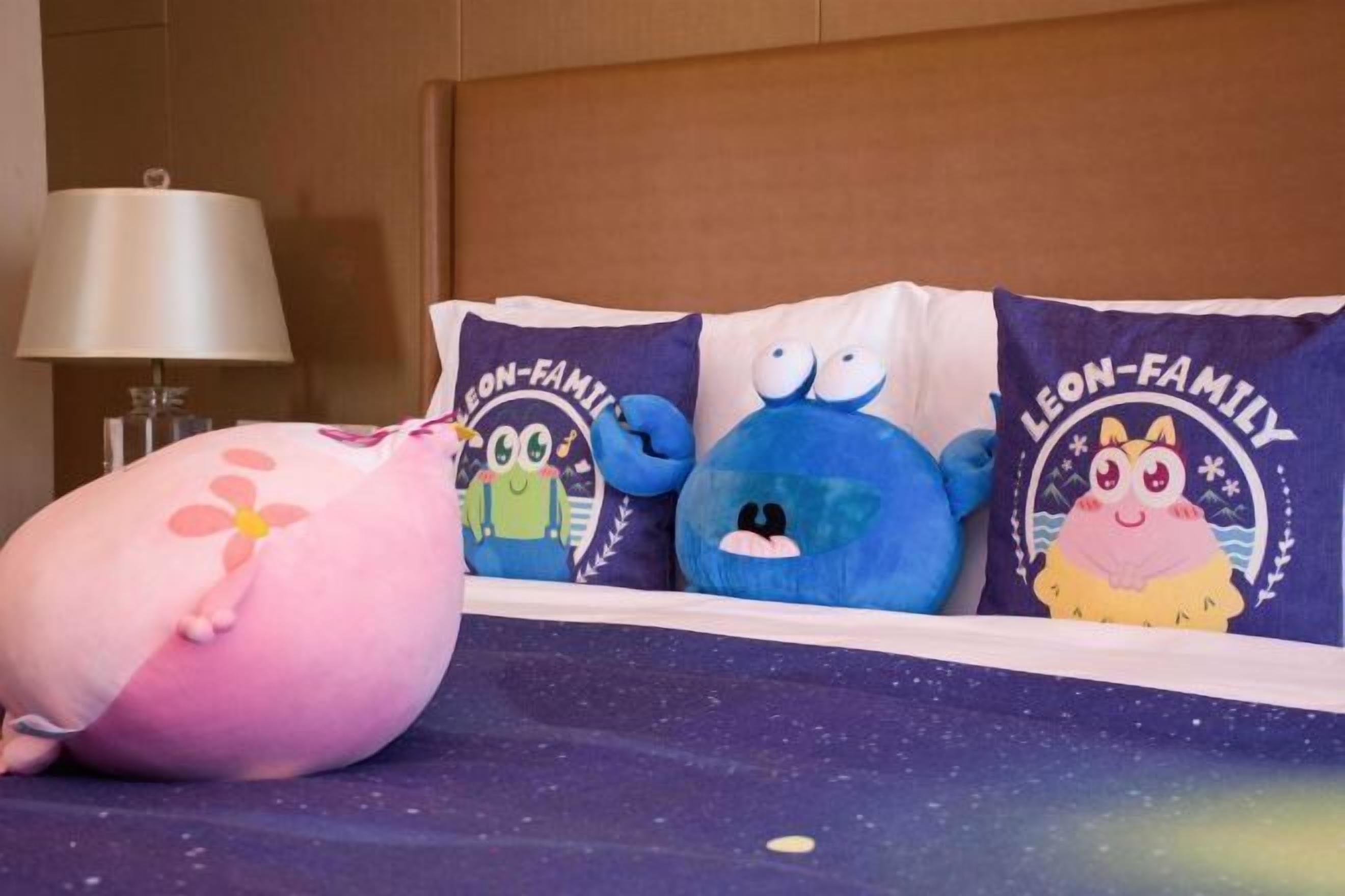 Una cama con un almohadón que muestra un personaje de caricatura y el texto "LEON-FAMILY".