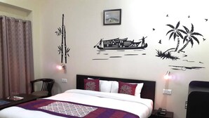 Een hotelkamer met een bed, nachtkastje, stoel en decoratieve muurkunst.