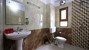 Un baño con lavamanos, espejo, inodoro y pared con diseño.
