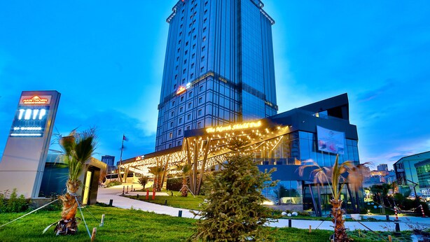 Un hotel moderno con un edificio alto y rectangular y un área de entrada bien iluminada.