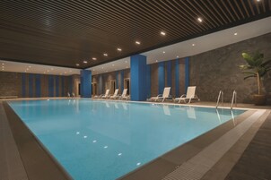 Una piscina techada, sillones reclinables de piscina