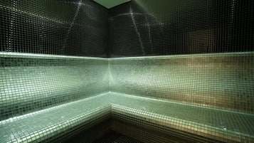 Un baño con suelo de baldosas y ducha en esquina.