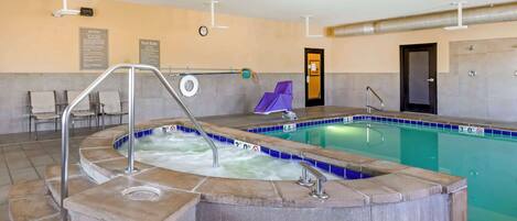 A spa area with a hot tub, a pool, and a seating area with chairs.