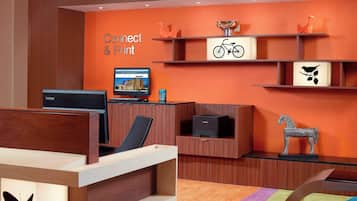 A reception area with a wooden desk, a computer, and a sign that reads "Connect & Print".