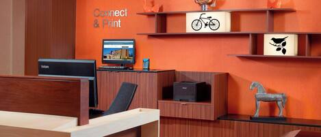 A reception area with a wooden desk, a computer, and a sign that reads "Connect & Print".