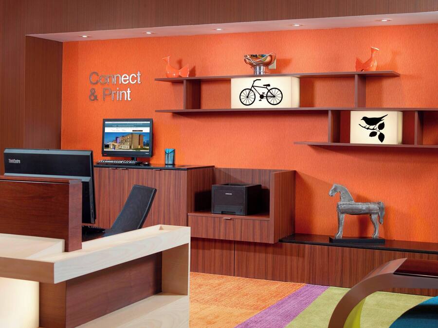 A reception area with a wooden desk, a computer, and a sign that reads "Connect & Print".
