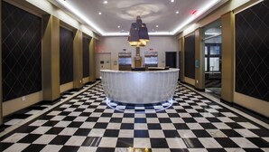 A hotel lobby with a checkered floor, a reception desk, and elevators. - Fairfield Inn & Suites by Marriott Philadelphia Downtown/Center City (Philadelphia)