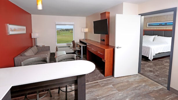 Une chambre d’hôtel équipée d’un bureau, d’un canapé, d’une télévision et d’un lit.