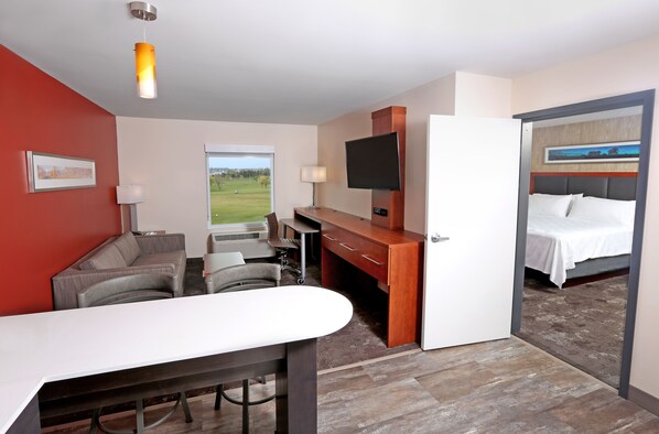Une chambre d’hôtel équipée d’un bureau, d’un canapé, d’une télévision et d’un lit.